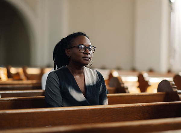 Woman sitting alone in church, reflecting